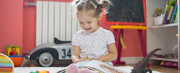 Petite fille qui joue dans sa chambre avec ses jouets et ses livres