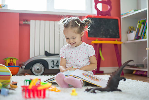 Petite fille qui joue dans sa chambre avec ses jouets et ses livres